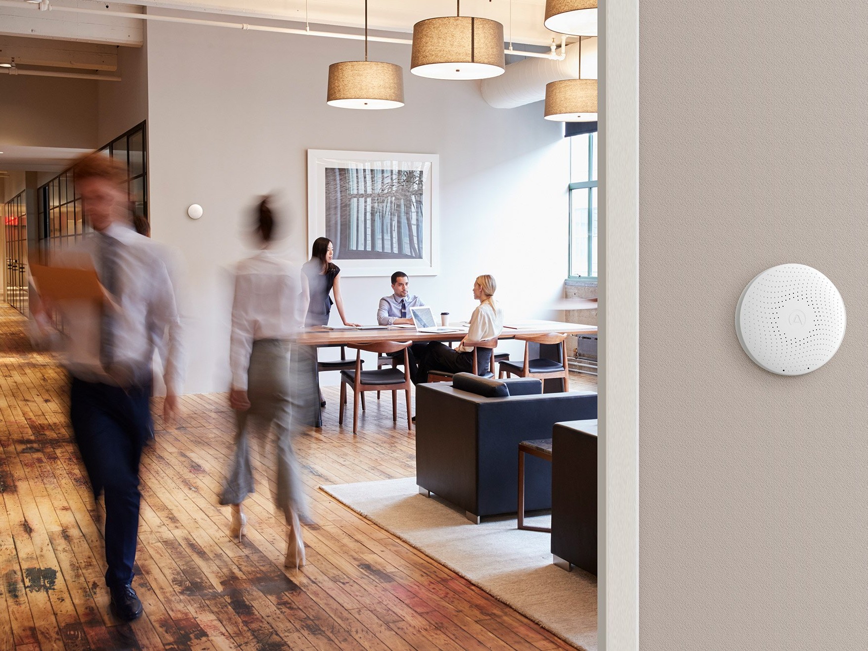 Open plan office space with people having a meeting at a table